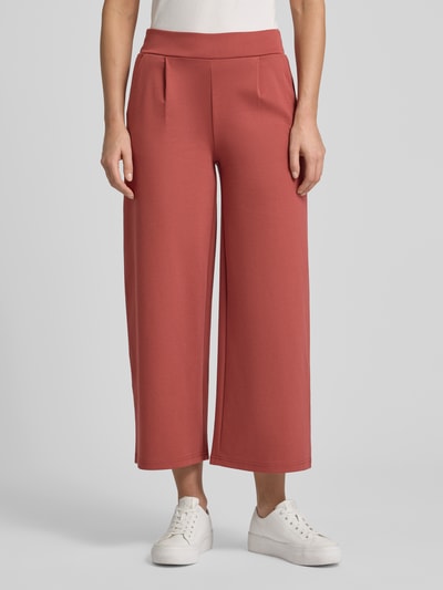 Frauenmodel trägt Wide Fit Stoffhose mit Viskose-Anteil Modell 'Kate' von ICHI in Rot mit Bundfalten und Gesäßtasche, Nahaufnahme Oberkörper