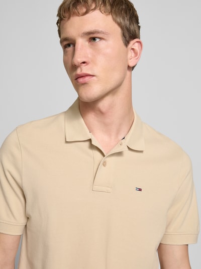 Männermodel trägt Regular Fit Poloshirt aus reiner Baumwolle von Tommy Jeans, Optik: Unifarben, Piqué, Logo-Stitching, Nahaufnahme Oberkörper.