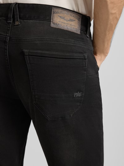 Männermodel trägt Jeans mit Label-Detail von PME Legend, Baumwoll-Mix mit Stretch-Anteil, schwarze Farbe, Detailaufnahme Gesäßtasche.