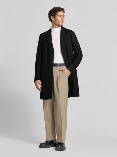 Männermodel trägt Mantel mit einreihiger Knopfleiste von BOSS in Schwarz, Longline, Wollmix, unifarben, Ganzkörperansicht von vorne.