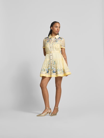 Frauenmodel trägt Minikleid mit Seide-Anteil von Self-Portrait in Gelb mit Blumenmuster, taillierte Passform, Brusttaschen, Gürtel, kurzärmelig, Baumwolle-Mix, glatte Textur, Ganzkörperansicht von vorne.