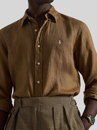 Mannenmodel draagt Regular Fit vrijetijdsoverhemd uit puur linnen van Polo Ralph Lauren, look: effen, logodetail, knoopsluiting, gevlamd garen. Nahaufnahme Oberkörper.