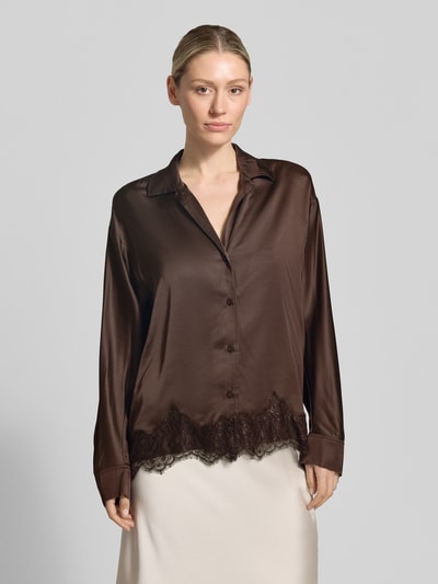 Frauenmodel trägt Relaxed Fit Bluse aus Viskose mit Spitzenbesatz von Jake*s Collection, dunkelbraun, seidige Textur, Reverskragen, V-Ausschnitt, Ganzkörperansicht von vorne. Rückenlänge 64 cm, Ärmellänge 55 cm, Größe 36.