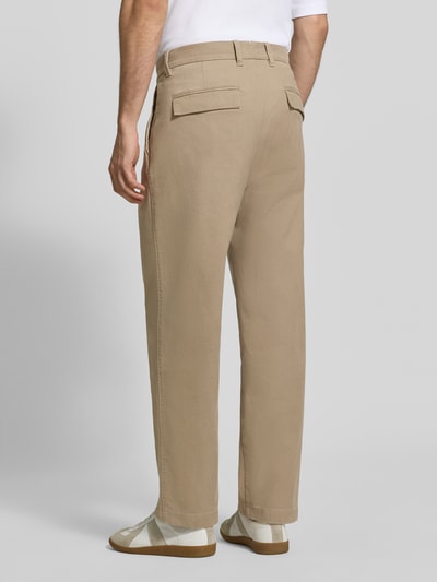 Männermodel trägt Weite Hose aus Baumwoll-Mix Modell 'Mossbo' von Marc O'Polo in Beige, glatte Struktur, Herren Weite Hose, Ganzkörperansicht Rückansicht.