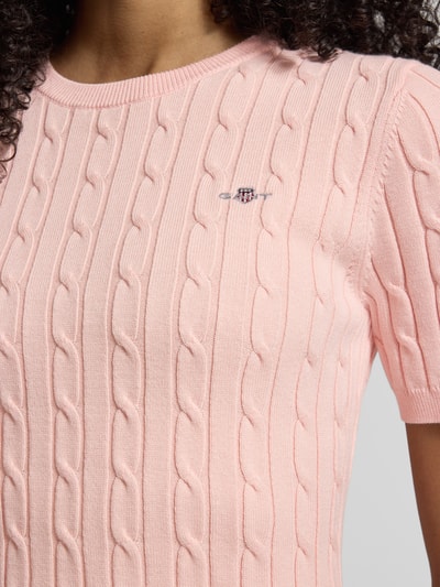 Frauenmodel trägt Strickshirt mit Zopfmuster und Label-Stitching von Gant in Rosa, Baumwoll-Mix, Nahaufnahme Oberkörper.