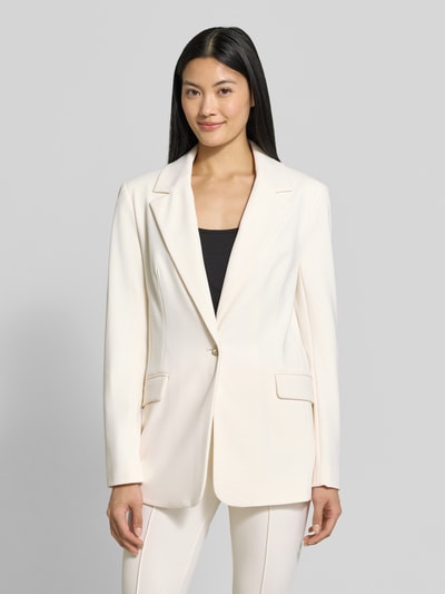 Frauenmodel trägt Slim Fit Blazer mit Stretch-Anteil Modell 'CLAUDIE' von GUESS in Hellbeige mit Reverskragen und Pattentaschen, Ganzkörperansicht von vorne.