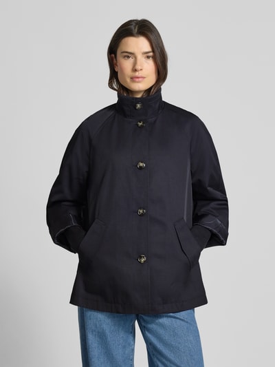 Modelka prezentuje Relaxed Fit Jacke mit Stehkragen von comma, mieszanka bawełny, wpuszczane kieszenie, stójka, guzikowa listwa, widok z przodu, ujęcie całej sylwetki. Długość tyłu w rozmiarze S: 70 cm, szerokość ramion w rozmiarze S: 48 cm, szerokość klatki piersiowej w rozmiarze S: 58 cm, długość rękawów w rozmiarze S: 73 cm.