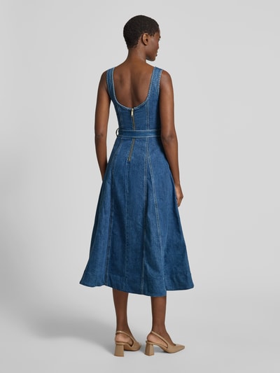 Frauenmodel trägt Mini-Jeanskleid aus Baumwoll-Mix von Self-Portrait in Denim-Optik, taillierte Passform, A-Linie, ärmelloses Design, Ganzkörperansicht Rückansicht.