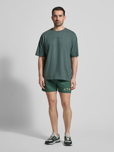 Männermodel trägt Shorts mit elastischem Bund von HALO, Material-Mix mit Stretch-Anteil, Regular-Fit, Label-Print, Ganzkörperansicht von vorne.