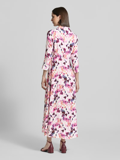 Frauenmodel trägt Hemdblusenkleid aus Viskose mit Knopfleiste Modell 'SAVANNA' von YAS, florales Muster in Rosa und Lila, Maxikleid, 3/4-Arm, Taillierter Schnitt, Ganzkörperansicht Rückansicht, Rückenlänge bei Größe S: 135 cm, Brustweite: 47 cm, Ärmellänge: 48 cm.
