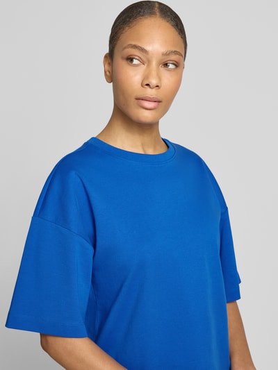 Frauenmodel trägt Oversized T-Shirt aus reiner Baumwolle von s.Oliver RED LABEL in kräftigem Blau, Optik: Unifarben, Passform: Oversized, Logo-Applikation, Rundhals-Ausschnitt, Ärmelform: Kurzarm, Materialverarbeitung: Jersey, Ganzkörperansicht von vorne.