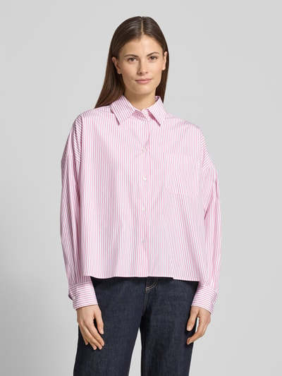 Modelka kobieca ma na sobie Oversized Hemdbluse aus reiner Baumwolle Modell 'AUREO' od Weekend Max Mara, różowo-białe paski, logo, krój oversize, czysta bawełna, widok całej sylwetki z przodu.