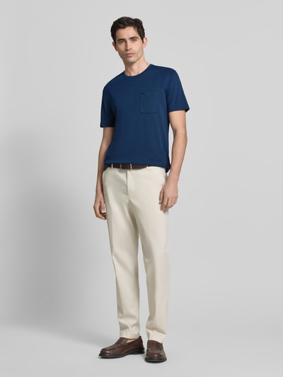Męski model nosi T-shirt mit Rundhalsausschnitt und Brusttasche von Christian Berg Men, mieszanka bawełny, krój regular fit, okrągły dekolt, brustasza, długość tyłu w rozmiarze M: 72 cm, widok całej sylwetki z przodu.