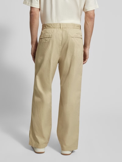 Männermodel trägt heren broek van puur katoen, los model, elastische band met knoop- en ritssluiting, steekzakken, model 'Ethan' van Wood Wood, bandwijdte maat M 42 cm, binnenbeenlengte 75 cm, zandkleurige stof met gladde structuur, achterzakken, geheellichaamsaanzicht achteraan.