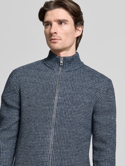 Männermodel trägt Regular Fit Strickjacke mit Woll-Anteil von Tom Tailor in Melange-Optik, Reißverschluss, Stehkragen, Nahaufnahme Oberkörper.