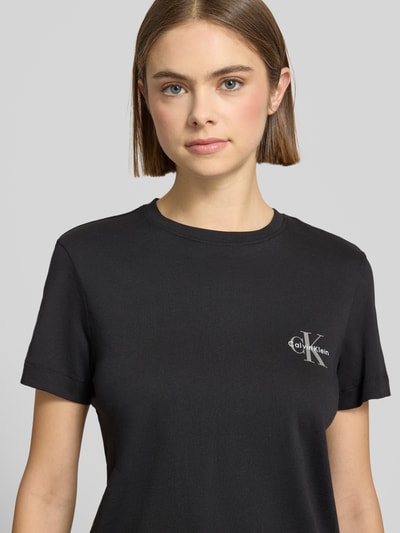 Vrouwenmodel draagt T-shirt Set met Logo en Ronde hals van Calvin Klein Jeans, zwart, puur katoen, regular fit, logoprint. Nahaufnahme Oberkörper
