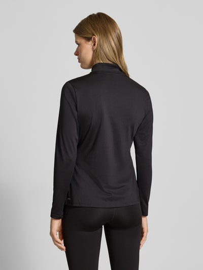 Kobiece model prezentuje czarną Jacke mit Stehkragen od PUMA, materiał z domieszką stretchu, slim fit, widok całej sylwetki z tyłu.
