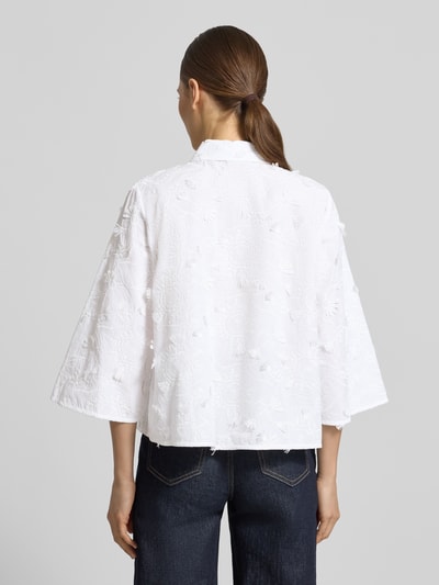 Frauenmodel trägt Regular Fit Bluse mit Stitchings Modell 'MAMICO' von EMME aus reiner Baumwolle in Weiß, 3/4-Arm, Rückenlänge 56 cm, Brustweite 46 cm, strukturierte Oberfläche mit floralen Mustern, Hemdblusenkragen, Knopfleiste, Ganzkörperansicht Rückansicht.