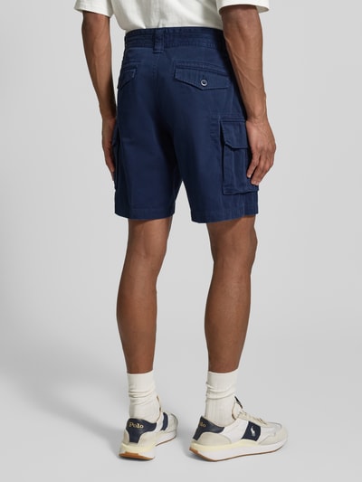 Mężczyzna nosi Szorty cargo Relaxed Fit z czystej bawełny od Polo Ralph Lauren, jednokolorowe, wykończenie z tkaną fakturą, widok całej sylwetki z tyłu.