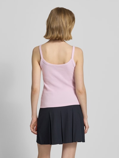 Vrouwenmodel draagt Slim Fit Tank Top uit mix van biologisch katoen model 'MAY' van Pieces, look: effen, fijnrib, rugdecolleté, geheel in zachte roze tinten, model met bandjes, rugdecolleté, fijnribstructuur, rugaanzicht.