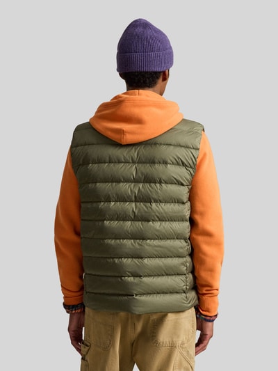 Männermodel trägt Regular Fit Weste mit Logo-Stitching von Polo Ralph Lauren in Oliv mit Steppstruktur, Ganzkörperansicht Rückansicht. Herren Weste von Polo Ralph Lauren.