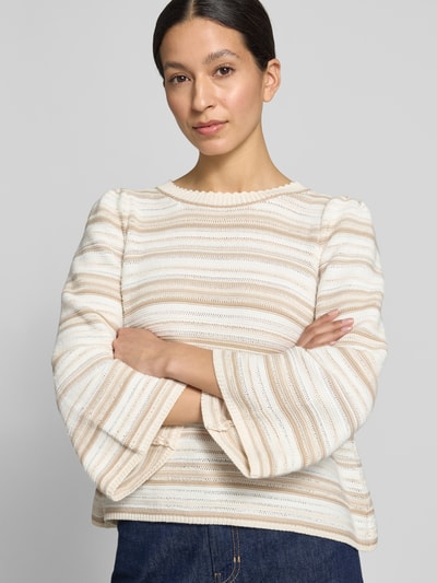 Frauenmodel trägt gestreiften, creme-weiß und beige Pullover mit strukturierter Textur, Nahaufnahme Oberkörper.