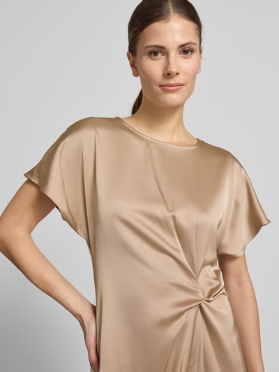 Modelka kobieca nosi Cocktailkleid mit Raffung und Kappärmeln od Christian Berg Cocktail, beżowa, lekko błyszcząca, gładka faktura, krój taliowany, dekolt okrągły, krótkie rękawy typu kappa, detal z marszczeniem, widoczny otwór na guziki z tyłu, materiał z mieszanki wiskozy, długość midi, szerokość w rozmiarze 36: 41 cm, długość tyłu: 122 cm, długość rękawa: 20 cm, zbliżenie na górną część ciała.