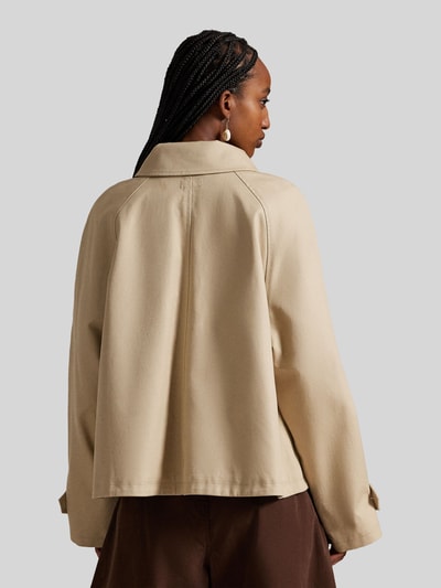 Vrouwenmodel draagt Regular Fit Trenchcoat uit puur katoen van Polo Ralph Lauren in effen beige met omgeslagen kraag, rugaanzicht