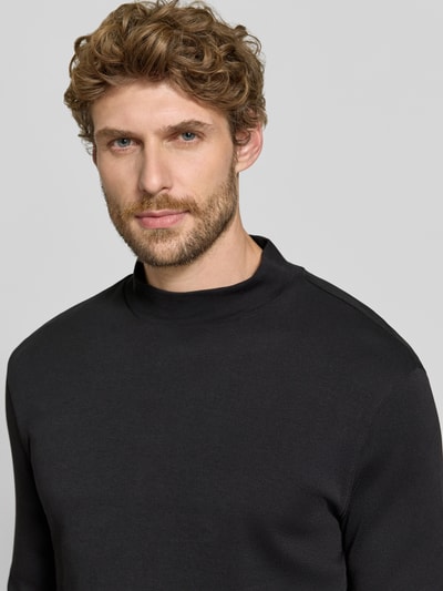 Männermodel trägt Regular Fit Longsleeve aus reiner Baumwolle mit Stehkragen von Christian Berg Men, schwarze Farbe, Nahaufnahme Oberkörper.