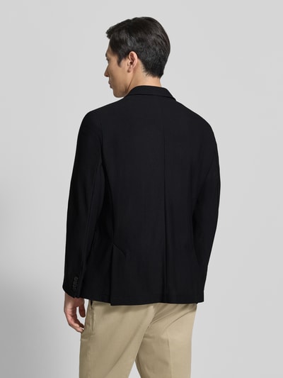 Männermodel trägt Regular Fit Anzugjacke mit Strukturmuster Modell 'Bob' von Zuitable in Schwarz, Elastischer-Material-Mix, Ganzkörperansicht Rückansicht.