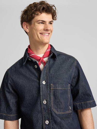 Männermodel trägt Regular Fit Jeanshemd mit Brusttasche von REVIEW in dunklem Blau, Reine Baumwolle, Nahaufnahme Oberkörper.