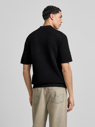 Männermodel trägt Regular Fit Poloshirt aus Baumwoll-Mix Modell 'MOON' von Only & Sons in Strickoptik mit Struktur-Muster, Ganzkörperansicht Rückansicht.