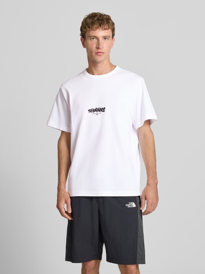 Männermodel trägt Relaxed Fit T-Shirt aus reiner Baumwolle mit Logo-Print von The North Face, weiß, schwarze Shorts, Ganzkörperansicht von vorne.