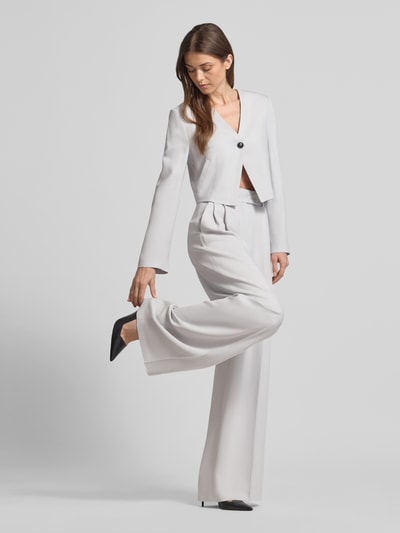 Frauenmodel trägt Weite Anzughose mit hoher Taille - curated by Vicky Heiler von SIC, hellgrau, Viskose-Elasthan-Mix, Wide Leg, Bügelfalten, Pattentaschen, Ganzkörperansicht von vorne.
