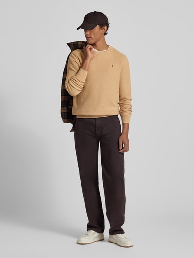Męski model nosi Sweter z dzianiny z wyhaftowanym logo od Polo Ralph Lauren, bawełna, krój regular fit, prążkowane wykończenia, okrągły dekolt, długość tyłu w rozmiarze M 72 cm, długość rękawów w rozmiarze M 69 cm, widok całej sylwetki z przodu