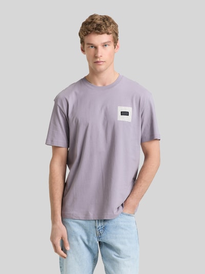 Mannenmodel draagt Relaxed Fit T-Shirt aus reiner Baumwolle van Tom Tailor Denim, uni, labelprint, ronde hals, korte mouw, puur katoen. Ganzkörperansicht van voren.