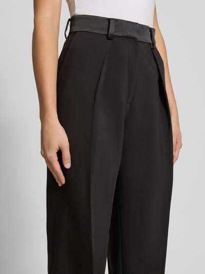 Frauenmodel trägt High Rise Stoffhose mit Gesäßtaschen von Bardot, schwarzer Material-Mix mit Viskose-Anteil, Bügelfalten, Nahaufnahme Oberkörper.