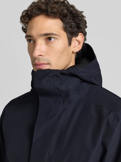 Männermodel trägt Regular Fit Jacke mit Kapuze Modell 'Adam' von Didriksons in Dunkelblau, glatte Struktur, Nahaufnahme Oberkörper. Herren Jacke, Kapuze, Eingrifftaschen, Rückenlänge 79 cm, Schulterbreite 46 cm, Brustweite 58 cm, Ärmellänge 73 cm.