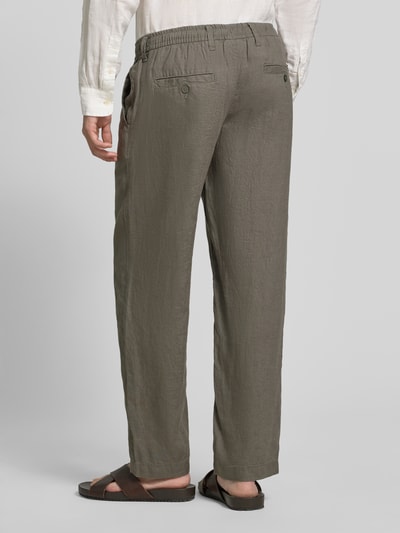 Männermodel trägt Leinenhose mit Eingrifftaschen Modell 'KARL LAWRENCE' von Jack & Jones Premium in Oliv, Straight Fit, Reines Leinen, Gesäßleistentaschen, Elastischer Bund, Knopf- und Reißverschluss, Ganzkörperansicht Rückansicht.