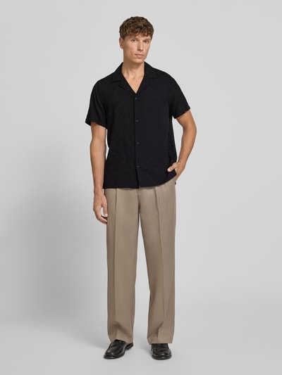 Männermodel trägt Regular Fit Freizeithemd aus Viskose-Baumwoll-Mix Modell 'Bijan' von DRYKORN, schwarz, Allover-Look, Ganzkörperansicht von vorne. Rückenlänge bei Größe M: 78 cm, Schulterbreite: 45 cm, Ärmellänge: 24 cm, Reverskragen, Knopfleiste.