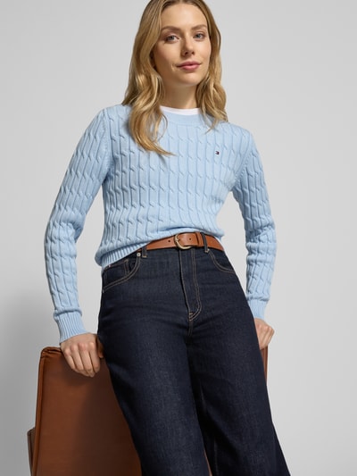 Frauenmodel trägt Slim Fit Strickpullover aus reiner Baumwolle von Tommy Hilfiger, niebieski, jednolity, krój slim fit, prążkowany, logo, długi rękaw, okrągły dekolt, bawełna, widok na cały przód.