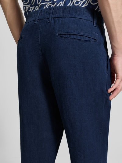 Männermodel trägt Tapered Fit Leinenhose mit steekzakken van MCNEAL, zuiver linnen, paspelzakken achter, detailaufnahme rückansicht
