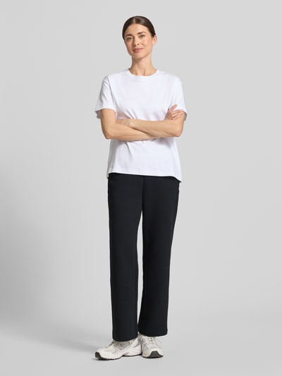 Frauenmodel trägt Sweatpants mit elastischem Bund und Logo-Print von ARMANI EXCHANGE in Schwarz mit Straight Fit und seitlichen Eingrifftaschen, Ganzkörperansicht von vorne.