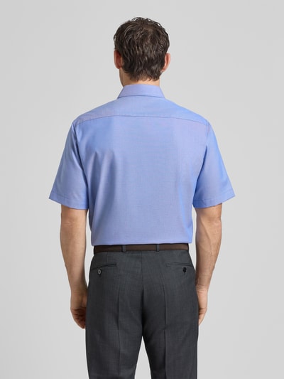 Männermodel trägt Comfort Fit Business-Hemd aus Baumwolle mit Kentkragen von ETERNA in Blau, 1/2-Arm, Rückenlänge 80 cm, Ganzkörperansicht Rückansicht.