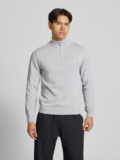 Męski model nosi Troyer mit Logo-Stitching und kurzem Reißverschluss od REVIEW, bawełniany mix, krój modern fit, szary, gładka tekstura, suwak, detale prążkowane, logo haft, długość pleców w rozmiarze M: 65 cm, długość rękawa w rozmiarze M: 66 cm, widok całej sylwetki z przodu.