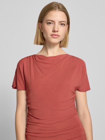 Frauenmodel trägt Cocktailkleid mit Wasserfall-Ausschnitt und Drapierungen von Christian Berg Cocktail in Rot, Viskose-Elasthan-Mix, Nahaufnahme Oberkörper.