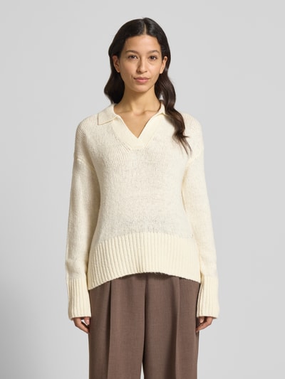 Frauenmodel trägt Strickpullover mit V-Ausschnitt von Fynch-Hatton in Creme, Baumwoll-Mix mit Stretch-Anteil, lockerer Schnitt, Resort-Kragen, gerippte Abschlüsse, braune Hose, Ganzkörperansicht von vorne.