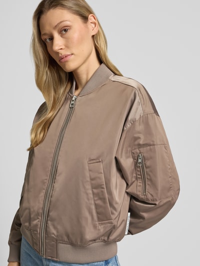 Kobiece model prezentuje Regular Fit Blouson mit College-Kragen od Marc O'Polo, efekt: jednolity kolor, imitacja satyny, splot twill, hydrofobowy, wpuszczane kieszenie, kieszeń zapinana na zamek błyskawiczny na rękawie, krój regular fit, kołnierz college, zamek błyskawiczny, długi rękaw, prążkowane zakończenia, widok z przodu, ujęcie górnej połowy ciała.