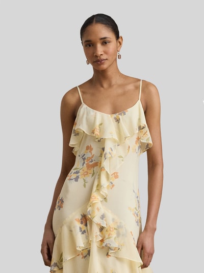 Frauenmodel trägt Fit and Flare Abendkleid mit Spaghettiträgern und Volants von Lauren Ralph Lauren in Hellgelb mit Blumenmuster, Nahaufnahme Oberkörper.