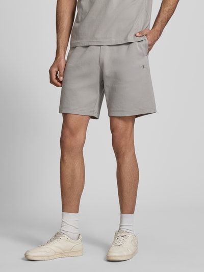 Männermodel trägt Shorts mit elastischem Bund und Label-Stitching von CHAMPION in Hellgrau, Baumwoll-Mix, Regular Fit, Nahaufnahme Oberschenkel.